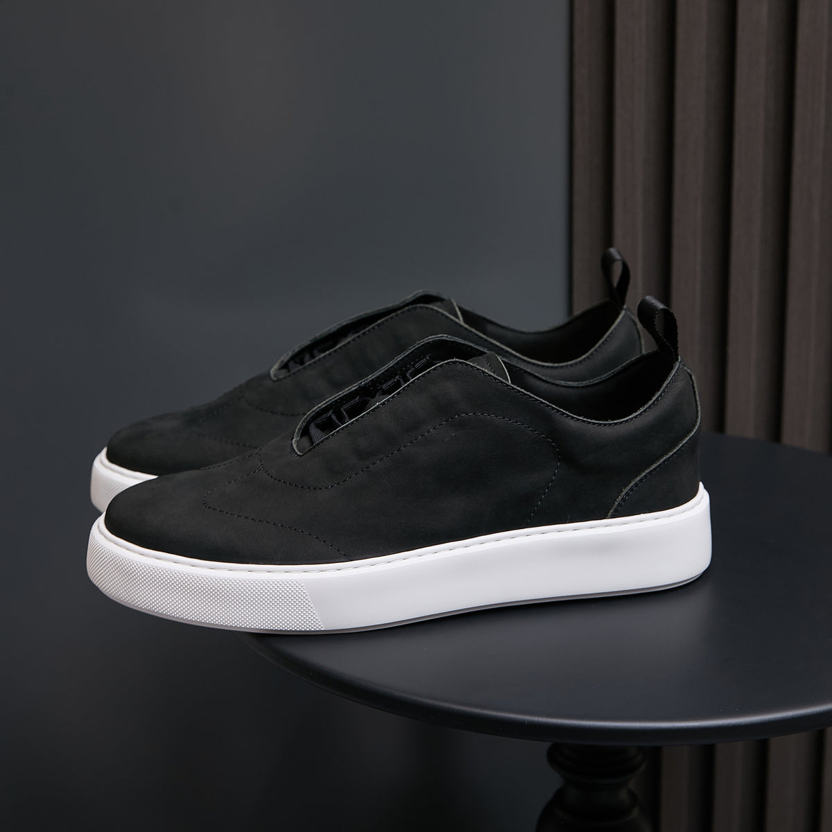Black leather sneakers with lace-up front and white rubber sole