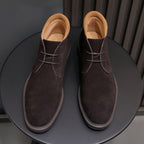 Dark brown suede lace-up chukka boots, front view, with tan inner lining