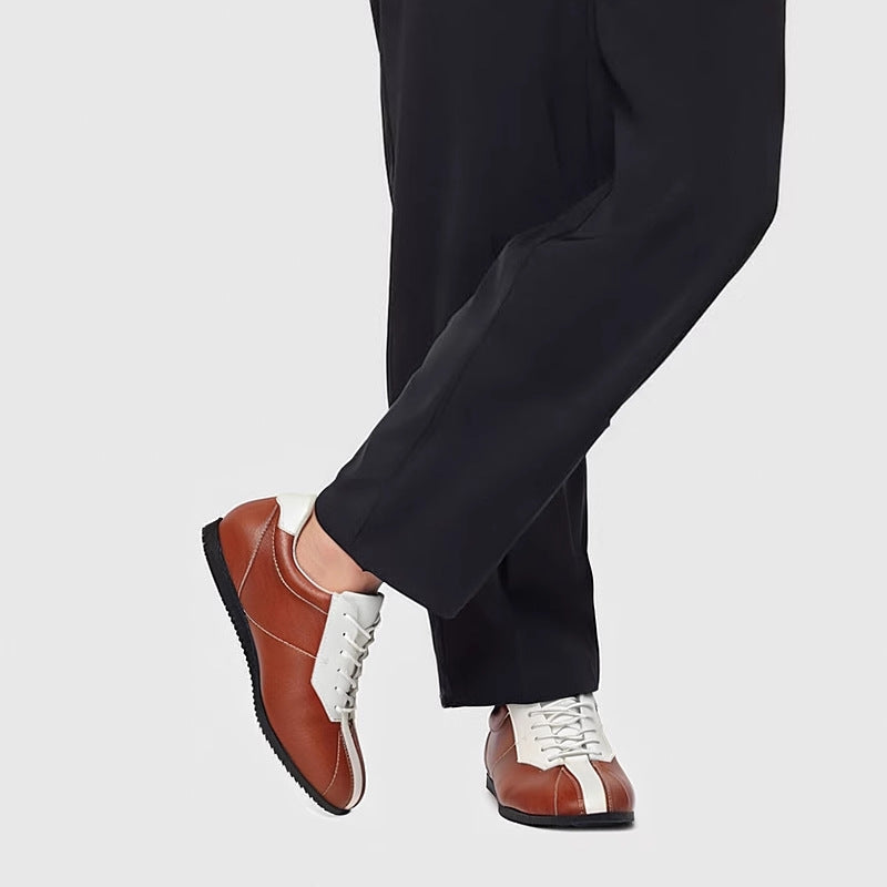 Brown leather sneakers with white laces and trim, showing side profile and sole.
