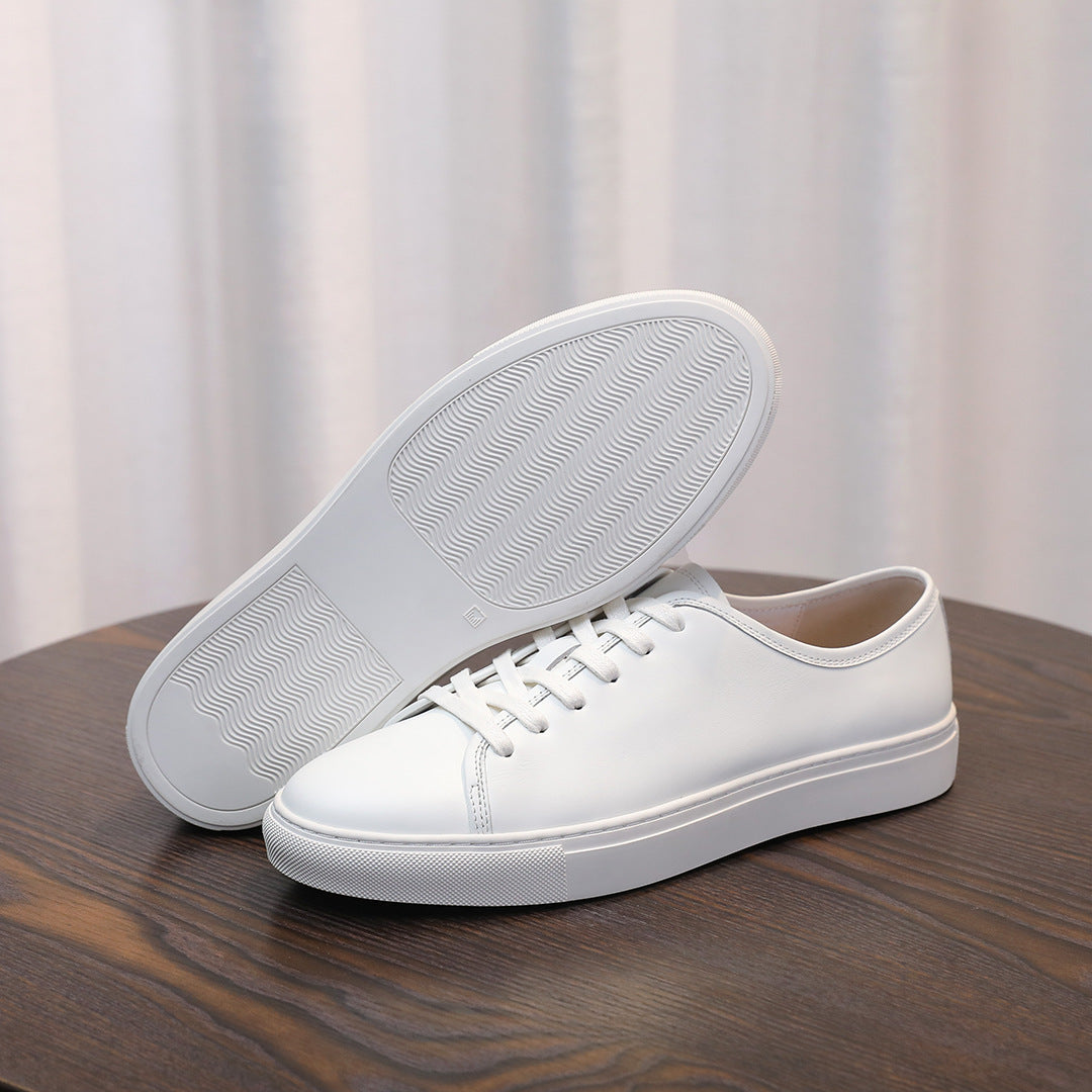Men's leather sneakers, white with textured rubber outsole visible and lace-up upper.