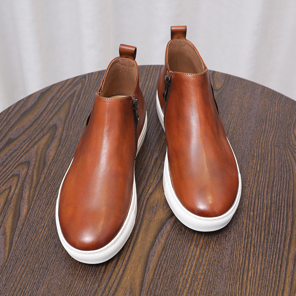 Brown leather side-zip ankle boots with pointed toe and white rubber soles, pair