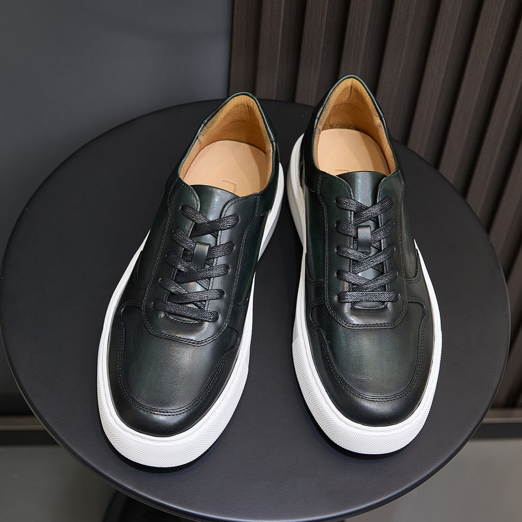 Pair of men's dark green leather sneakers with black laces and white sidewall trim