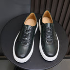 Pair of men's dark green leather sneakers with black laces and white sidewall trim