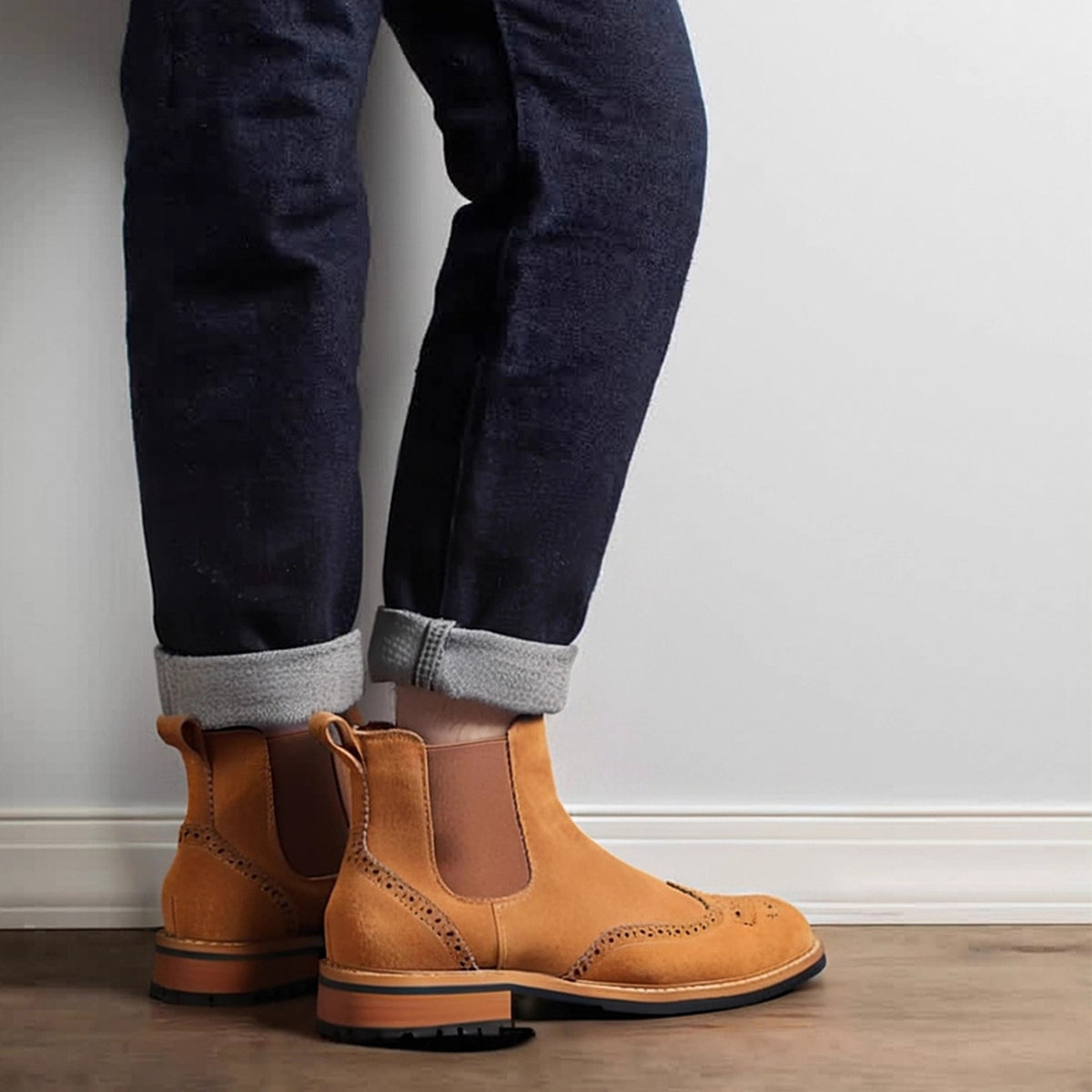 Pointed-toe suede Chelsea boots in brown, worn with dark jeans and ribbed socks