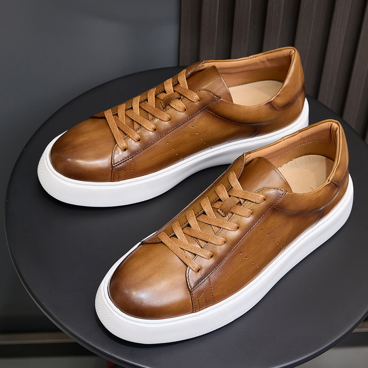 Men's brown leather lace-up sneakers, side-by-side angle with textured laces and white sole