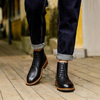 Black leather lace-up dress boots with pointed toe and orange edge welt