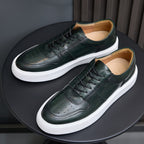 Leather sneakers in dark green, low-profile lace-up with white rubber sole.