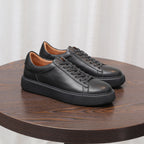 Men's black leather sneakers with lace-up front and stitched panels, cushioned platform sole