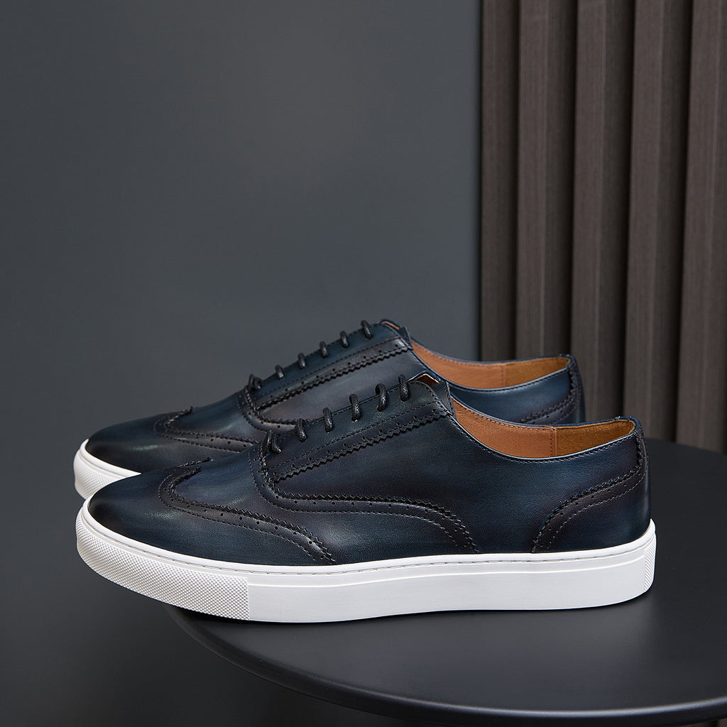 Dark blue leather low-top sneakers with lace-up front and white sole
