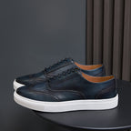 Dark blue leather low-top sneakers with lace-up front and white sole