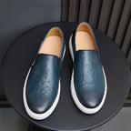 Men's blue leather slip-on sneakers with tan lining and white rubber soles
