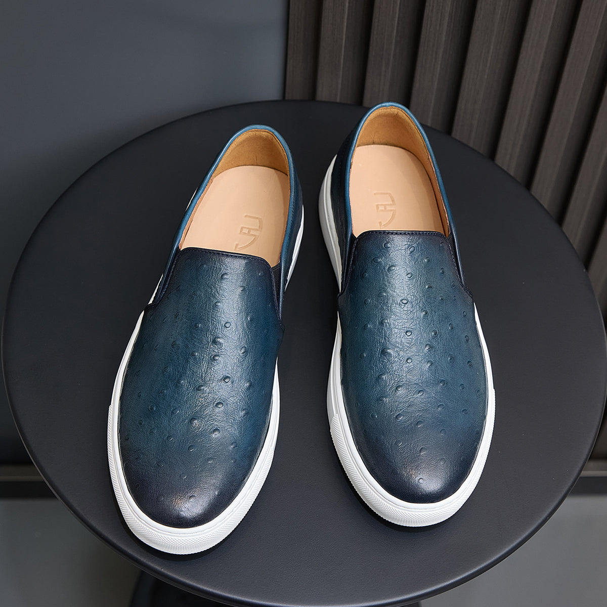 Men's blue leather slip-on sneakers with tan lining and white rubber soles