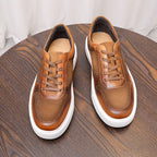 Pair of brown leather lace-up sneakers with padded collar and white rubber sole