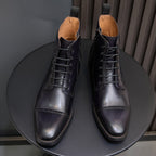 Men's dark leather lace-up dress boots pair from front view with pointed toe