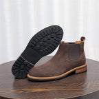 Men's suede chelsea dress boot in dark brown with visible tread outsole and elastic gore