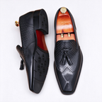 Pair of men's exotic leather loafers in sleek black, designed as slip-on dress shoes for formal wear.
