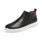 Black leather side-zip dress boot with pointed toe and white rubber sole
