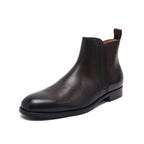Pointed-toe leather side-zip dress boot in black, front three-quarter view on white